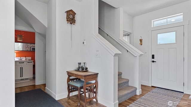 foyer entrance featuring stairway, wood finished floors, and baseboards