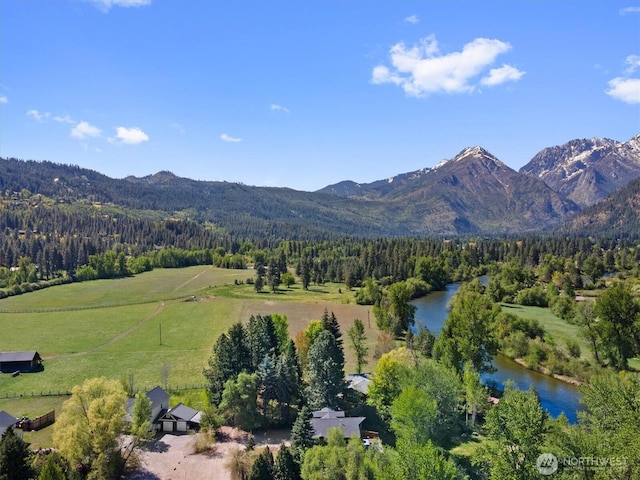aerial view of property's location featuring a heavily wooded area and a water and mountain view