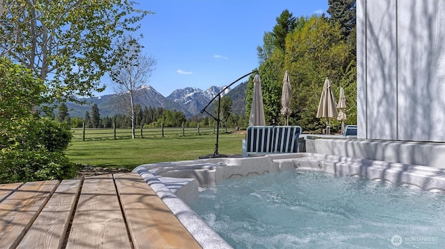 view of patio featuring a mountain view, a hot tub, and a view of countryside