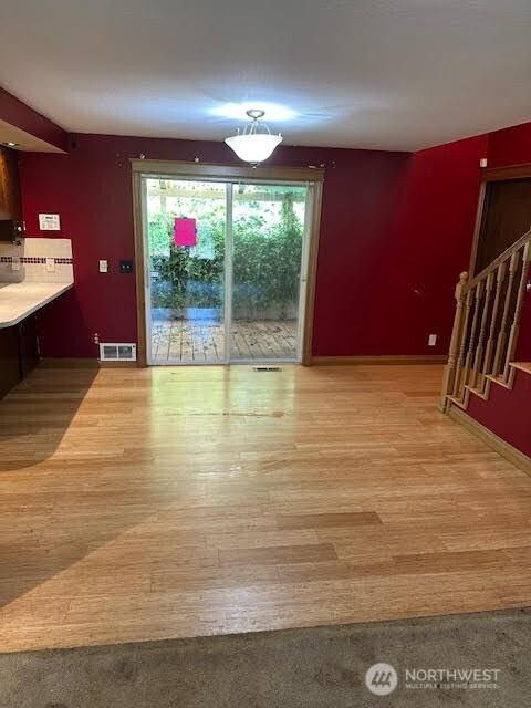 816 Sunrise Ln, Centralia, WA 98531 - unfurnished dining area with stairs, wood finished floors, and baseboards