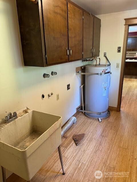 816 Sunrise Ln, Centralia, WA 98531 - laundry area with strapped water heater, light wood-style floors, cabinet space, and hookup for an electric dryer