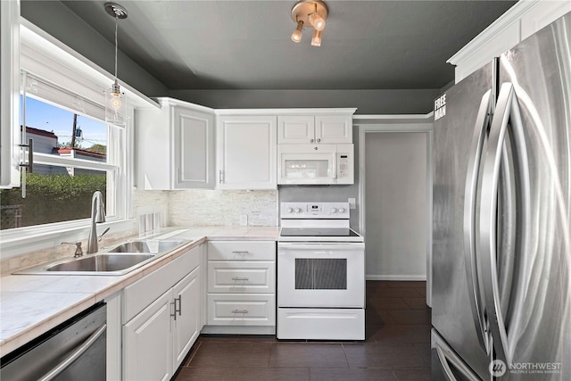 kitchen with appliances with stainless steel finishes, a sink, and white cabinets