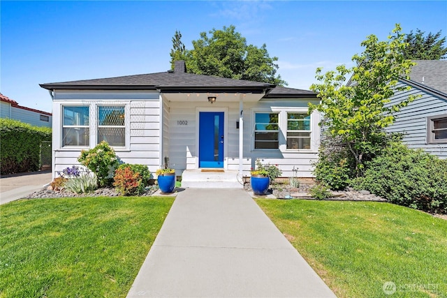 view of front of home featuring a front yard and a chimney