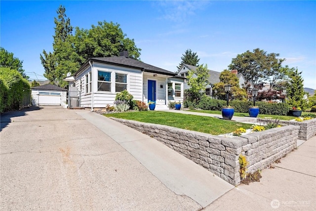 view of front of home featuring a front lawn, an outbuilding, and a detached garage