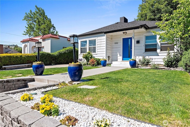 view of front of home featuring a front yard and a chimney