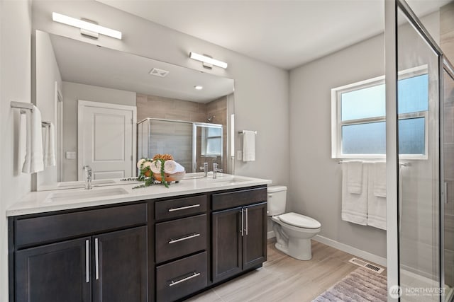 207 207th St SE Unit Eh49, Bothell, WA 98012 - bathroom with toilet, double vanity, a stall shower, baseboards, and wood finished floors