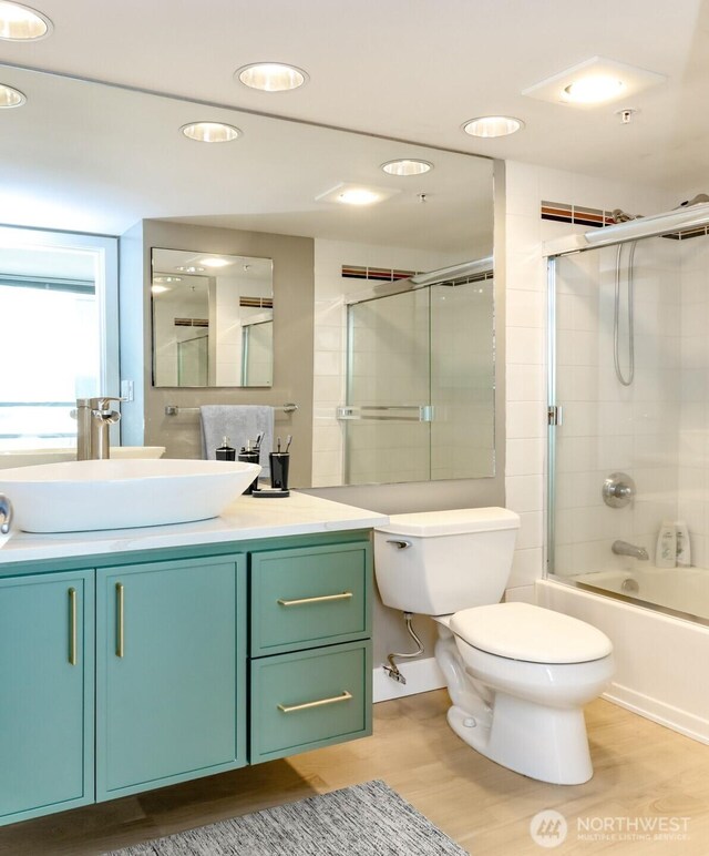 full bathroom featuring wood finished floors, toilet, vanity, washtub / shower combination, and recessed lighting