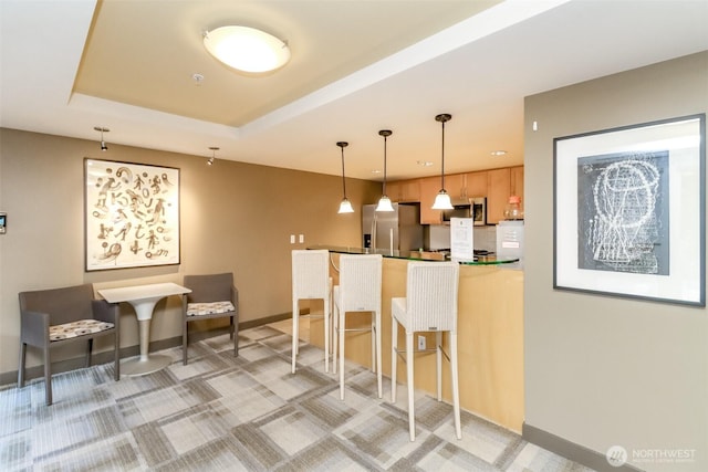 kitchen featuring appliances with stainless steel finishes, hanging light fixtures, a peninsula, baseboards, and recessed lighting