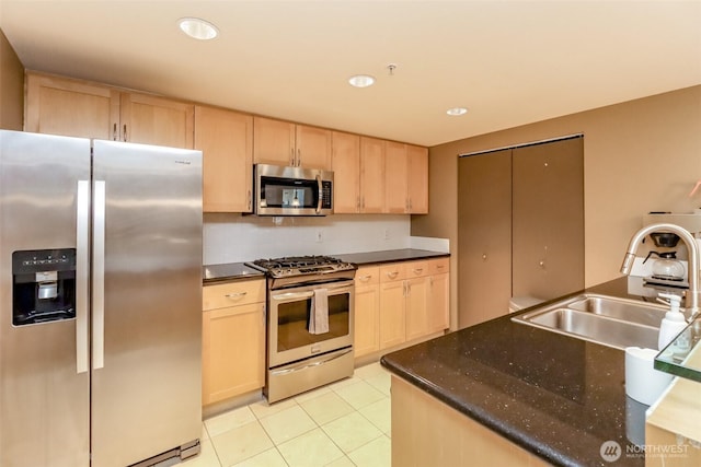 kitchen with stainless steel appliances, light brown cabinets, a sink, light tile patterned floors, and recessed lighting