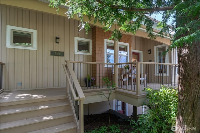 view of exterior entry featuring covered porch and board and batten siding