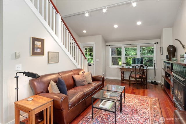 living area featuring wood finished floors, stairway, track lighting, baseboards, and recessed lighting