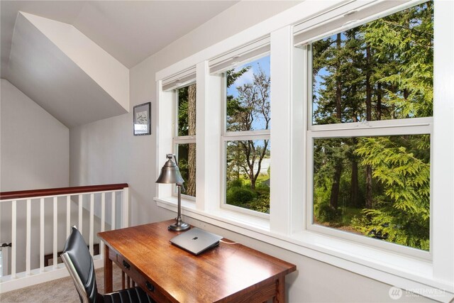 carpeted home office with lofted ceiling