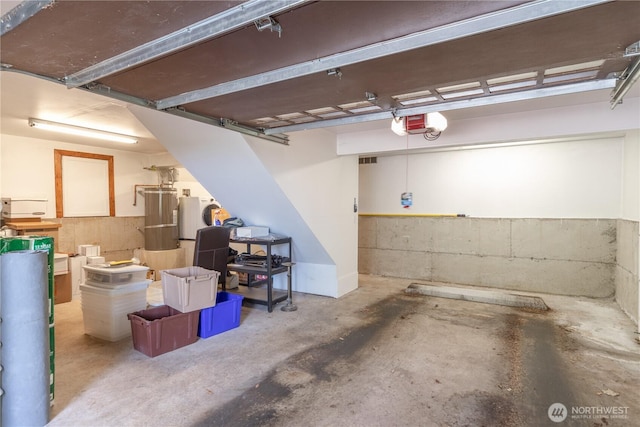 garage with gas water heater and a garage door opener