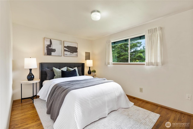 bedroom with wood finished floors and baseboards