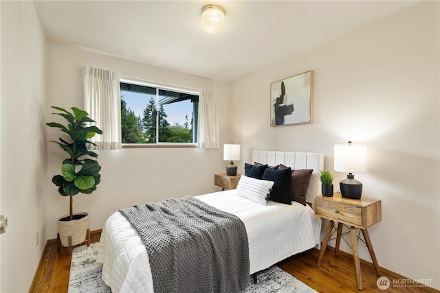 bedroom with wood finished floors and baseboards