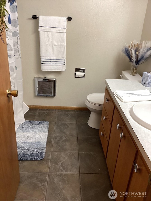 511 I St SW, Quincy, WA 98848 - bathroom with toilet, vanity, heating unit, baseboards, and tile patterned floors