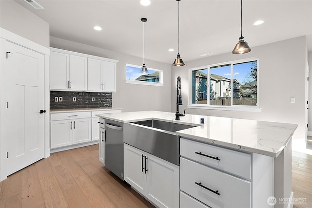 15709LOT12 SE 257th St, Covington, WA 98042 - kitchen featuring stainless steel dishwasher, a sink, light wood-type flooring, decorative backsplash, and hanging light fixtures