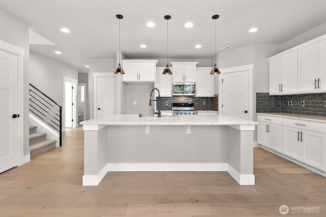 15709LOT12 SE 257th St, Covington, WA 98042 - kitchen featuring stainless steel microwave, stove, recessed lighting, light wood finished floors, and baseboards