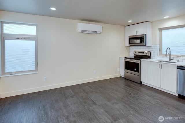 3325 Martin Luther King Jr Way S, Seattle, WA 98144 - kitchen with stainless steel appliances, an AC wall unit, a sink, light countertops, and backsplash