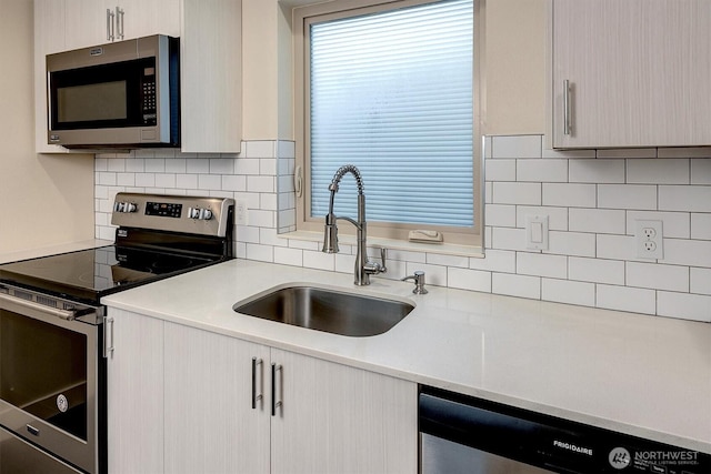 3325 Martin Luther King Jr Way S, Seattle, WA 98144 - kitchen featuring appliances with stainless steel finishes, a sink, light countertops, and decorative backsplash
