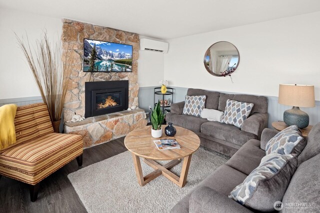 2967 Saratoga Rd, Langley, WA 98260 - living area featuring a wall mounted air conditioner, wood finished floors, a fireplace, and wainscoting