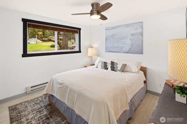 2967 Saratoga Rd, Langley, WA 98260 - bedroom featuring a baseboard heating unit, light wood-type flooring, and a ceiling fan
