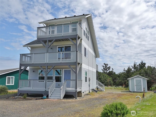 view of front of property with a balcony, a storage unit, an outdoor structure, and a porch