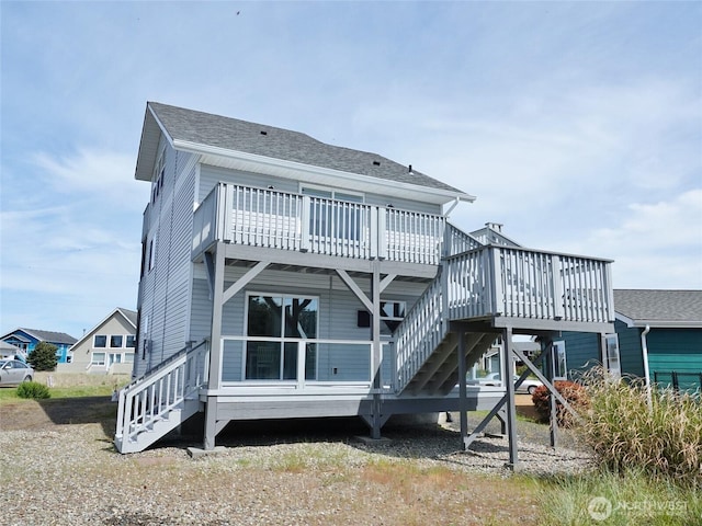 back of house with a wooden deck, stairway, and roof with shingles