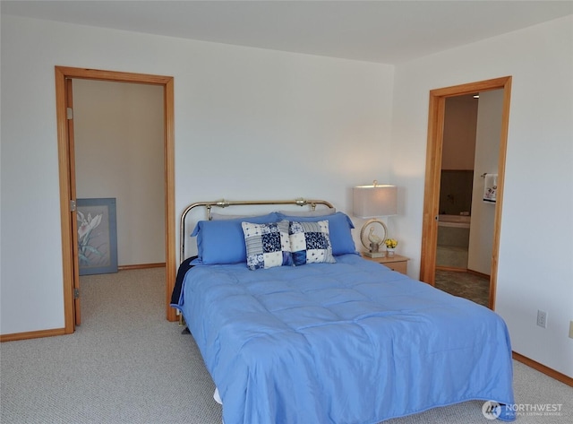 carpeted bedroom with baseboards and ensuite bath