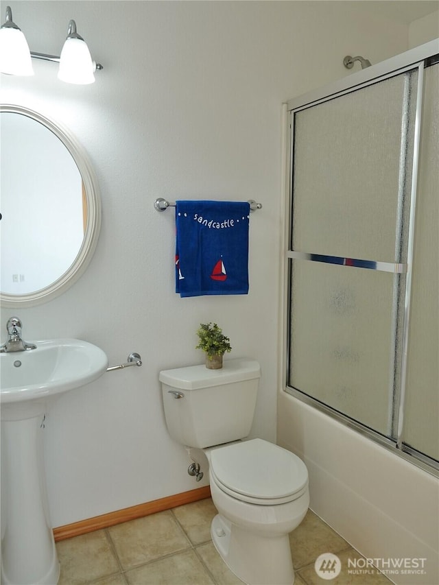 bathroom with toilet, tile patterned flooring, enclosed tub / shower combo, and baseboards
