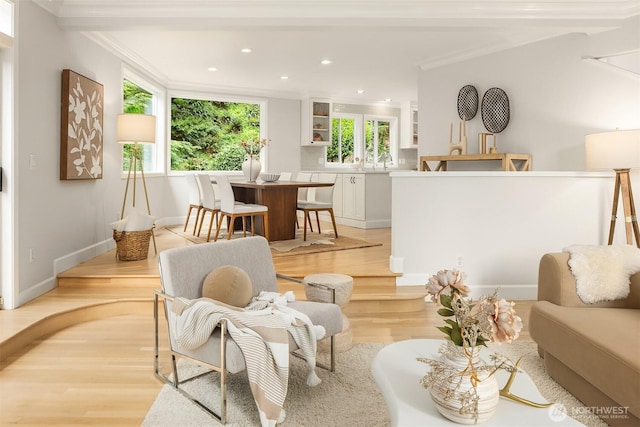 living room featuring ornamental molding, light wood finished floors, recessed lighting, and baseboards