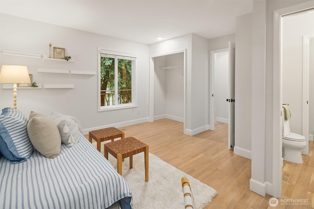 bedroom featuring light wood-type flooring, baseboards, and a closet
