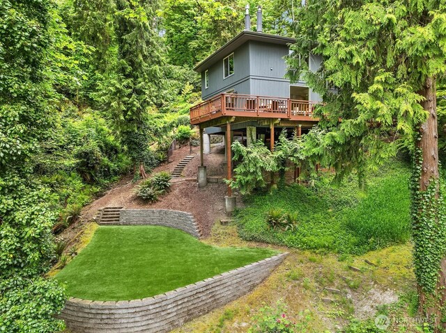 back of house featuring a deck and a lawn