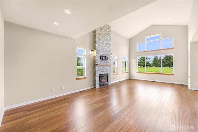 549 E Maberry Dr, Lynden, WA 98264 - unfurnished living room featuring wood-type flooring, a stone fireplace, high vaulted ceiling, and baseboards