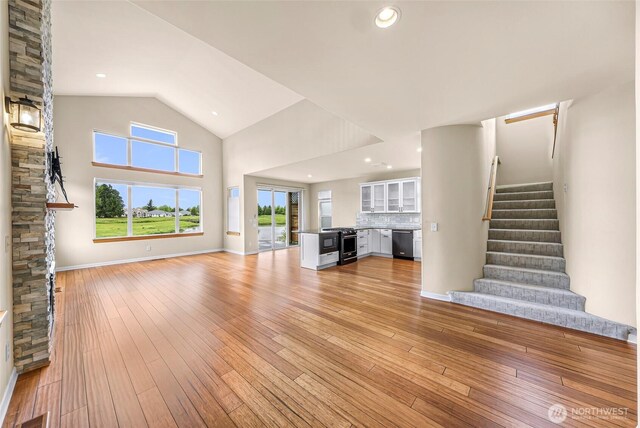 549 E Maberry Dr, Lynden, WA 98264 - unfurnished living room featuring stairs, light wood-style floors, baseboards, and high vaulted ceiling