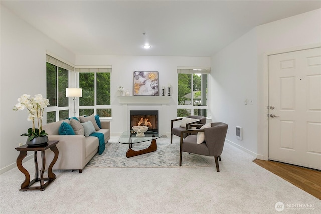 living room featuring a glass covered fireplace and baseboards