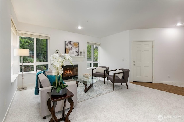 living room featuring baseboards, a glass covered fireplace, carpet flooring, and recessed lighting