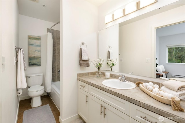bathroom featuring a baseboard heating unit, vanity, toilet, baseboards, and shower / tub combo
