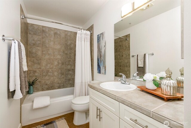 full bathroom featuring vanity, shower / tub combo, and toilet