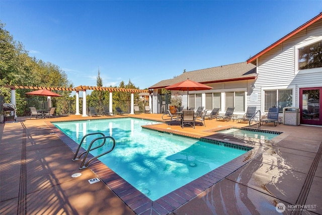 community pool featuring a community hot tub, a patio, fence, and outdoor dining space