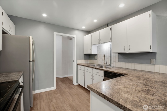 kitchen featuring a sink, light wood-style floors, white cabinetry, recessed lighting, and backsplash