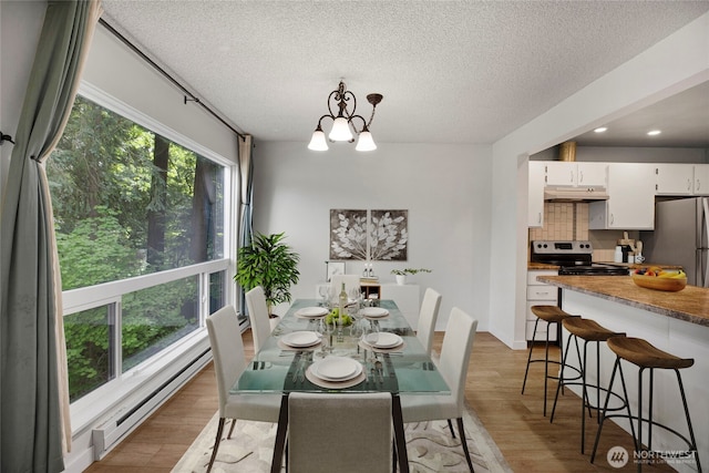 13739 15th Ave NE Unit B9, Seattle, WA 98125 - dining space featuring light wood-type flooring, a baseboard radiator, a textured ceiling, a chandelier, and recessed lighting