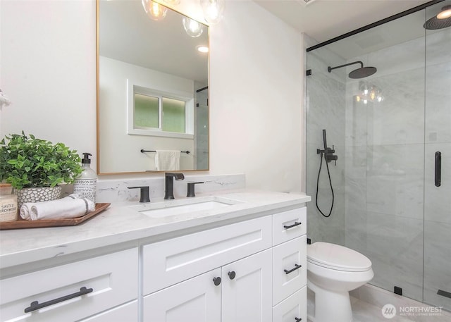 bathroom with a stall shower, vanity, and toilet