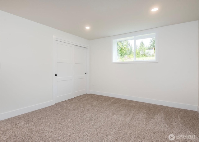 unfurnished bedroom with carpet floors, baseboards, recessed lighting, and a closet