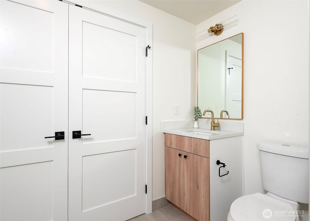 half bathroom with toilet and vanity
