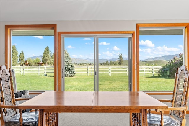 dining space with a view of countryside, a mountain view, and plenty of natural light