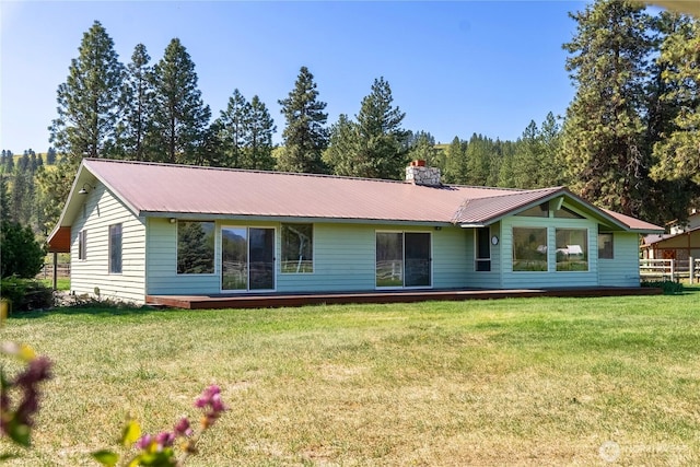 view of front of house with a front yard, metal roof, and a chimney