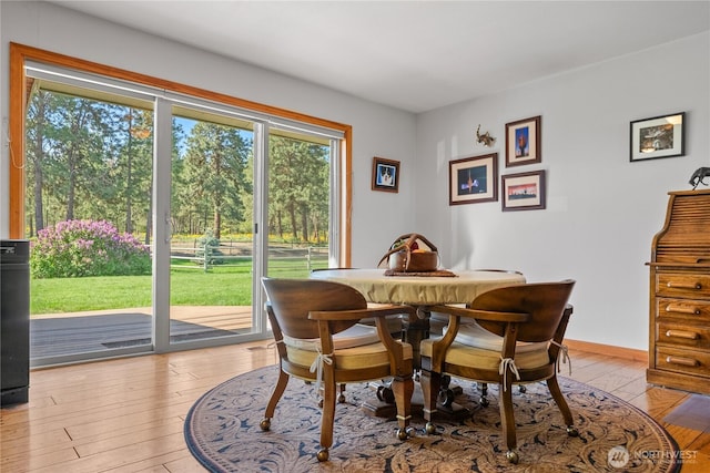 dining area with light wood-type flooring and baseboards