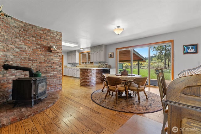dining room with a wood stove and light wood finished floors