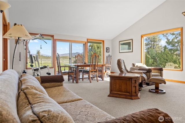 carpeted living room featuring vaulted ceiling, plenty of natural light, a mountain view, and baseboards
